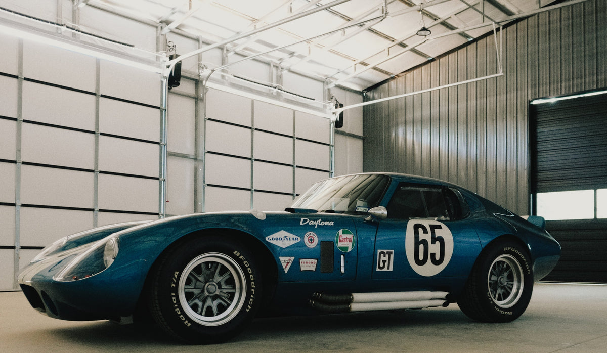 Blue classic race car parked in a garage